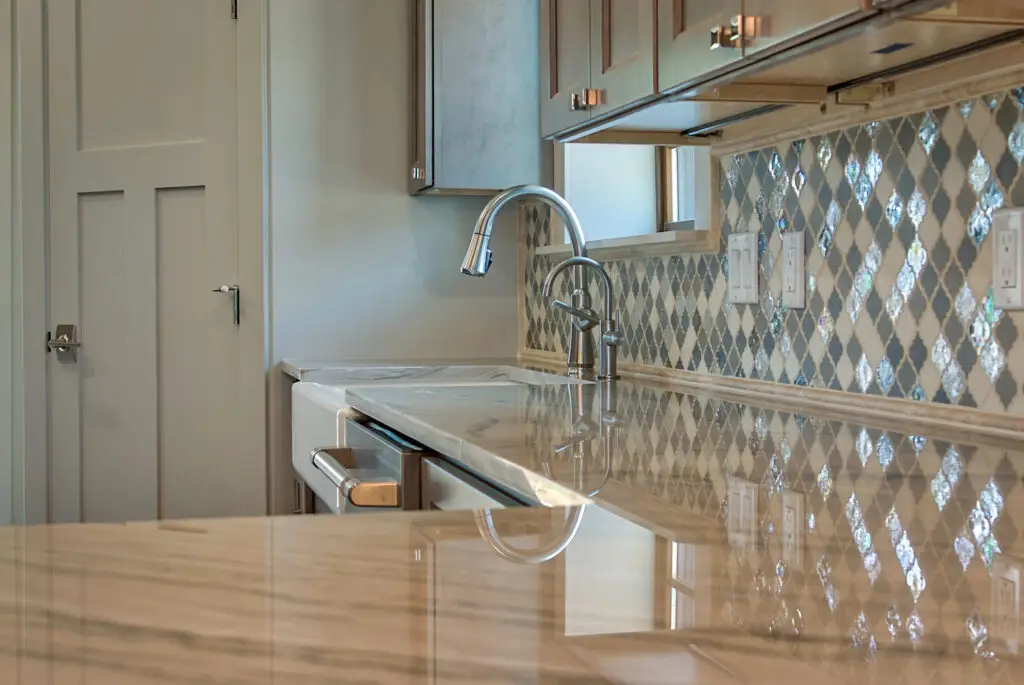Interior photo of custom-built home by Harvell Homes in Powell, Wyoming featuring a farmhouse kitchen sink, premium appliances, cabinet and door finishes, and luxury backsplash