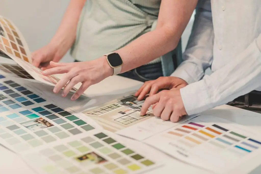 Two people planning a project with color palettes on a table, collaborating creatively.